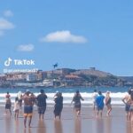 O turista Screenshore como um jogador de bombeiros correndo para passar pela praia de ar espanhol