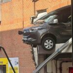 Três trabalharam como um carro de van ara na parede do carro e mostram no meio do ar