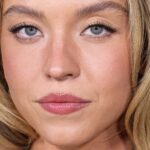 Sydney Sweeeney remove sua jaqueta de pele em branco por baixo